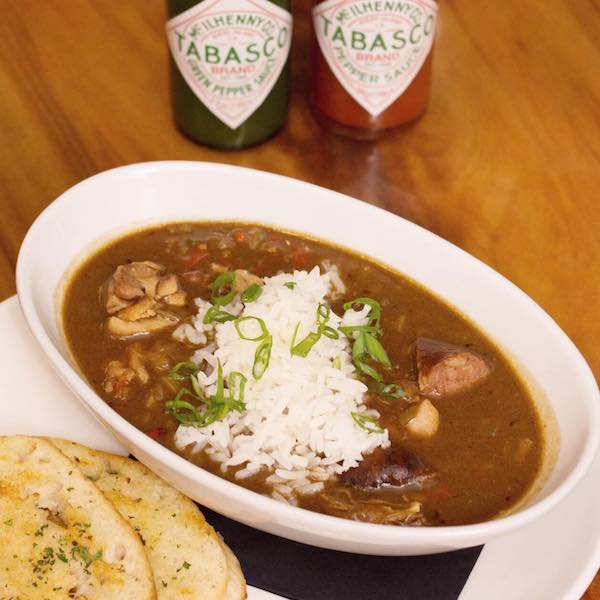 An oval bowl of seafood gumbo with white rice from Great Food at New Orleans Sports Venues