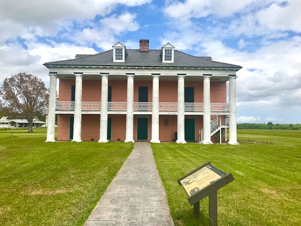 A red brick plantation home with white pillars that we saw after Lunch at Cochon Butcher in New Orleans