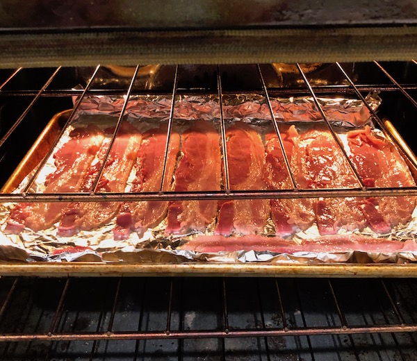 Bacon for the Jimmy's Milan Salad cooking in the oven on a foil lined sheet pan