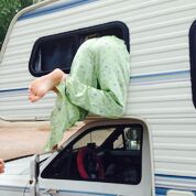 A girls legs in light green pjs hanging out of the window of an RV from Pink Steering Wheel Chronicles