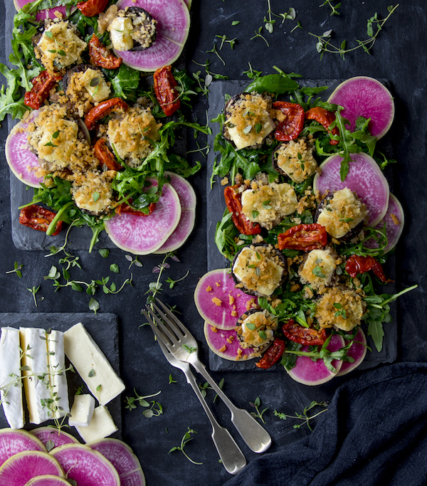 Plates of salad topped with pink radishes and brie-stuffed mushrooms from Seriously Good Salads