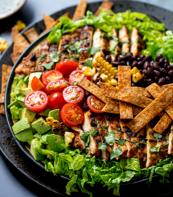 A platter of greens, tomatoes, chicken and tortilla strips from Seriously Good Salads