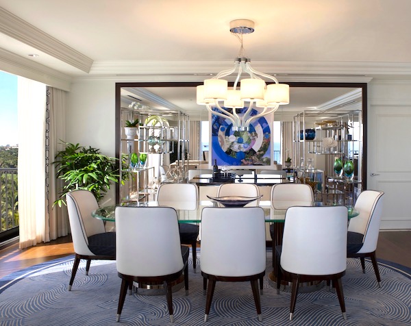 A dining room of a suite with blue carpet and white chairs at The Breakers Palm Beach