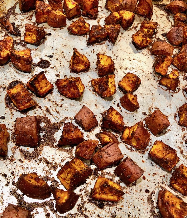 Cinnamon Garlic Roasted Sweet Potatoes on a sheet pan ready to serve.