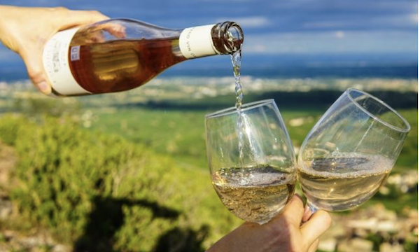 A bottle of white wine being poured into a glass as part of the Wine Train Colorado