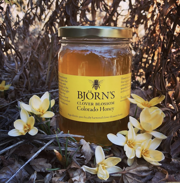 A jar of honey surrounded by flowers from Savor The Flavors Of Fall In Colorado