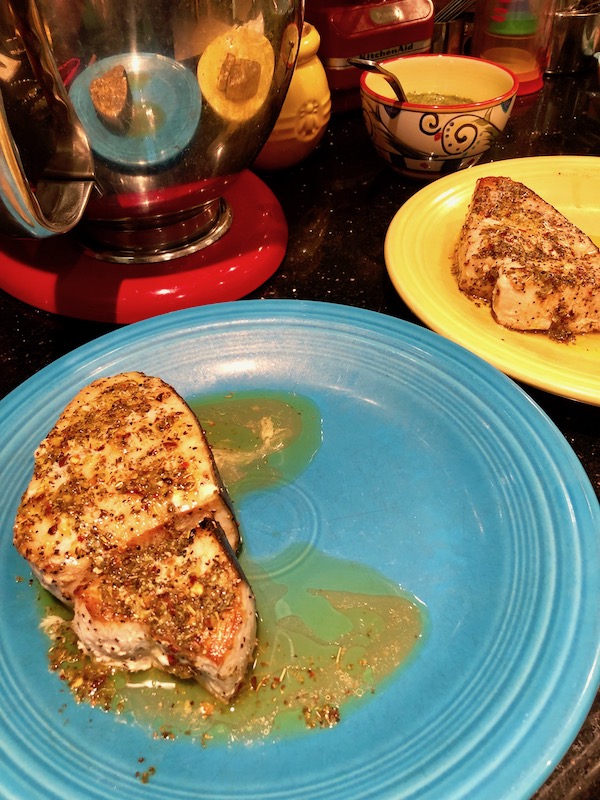 Cooked Swordfish Steaks with marinade one on a turquoise plate and one on yellow for my Sicilian Swordfish with Tomatillo Salsa