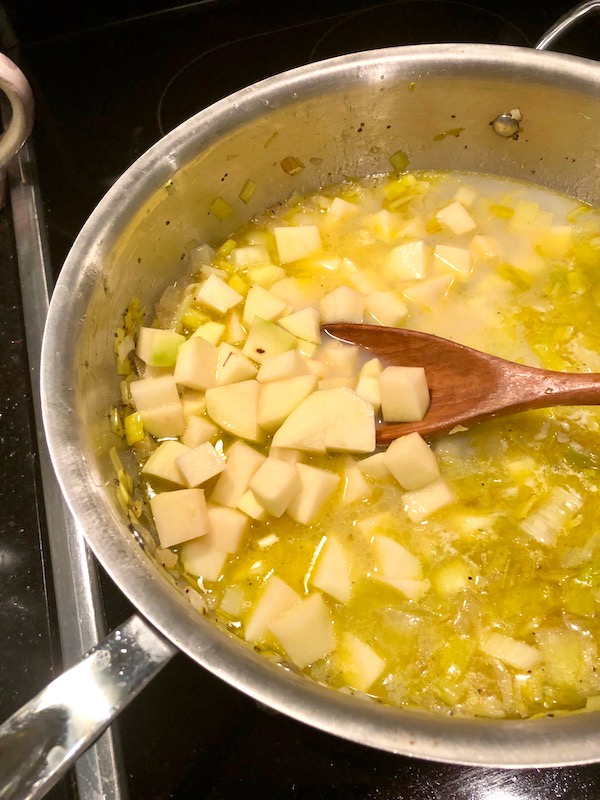 Peeled potato chunks are added to the wine, leeks and onions for New England Clam Chowder