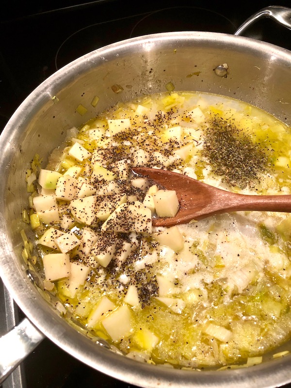 Dried herbs and clam juice added to the other ingredients for New England Clam Chowder