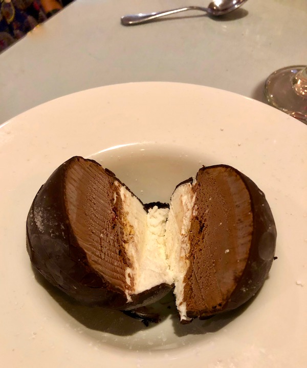 A white bowl filled with a ball of chocolate covered vanilla and chocolate ice cream at Red Room In Ventnor NJ.