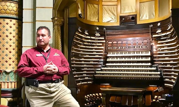 A man in a red shirt by the huge organ which is the World's Largest Pipe Organ