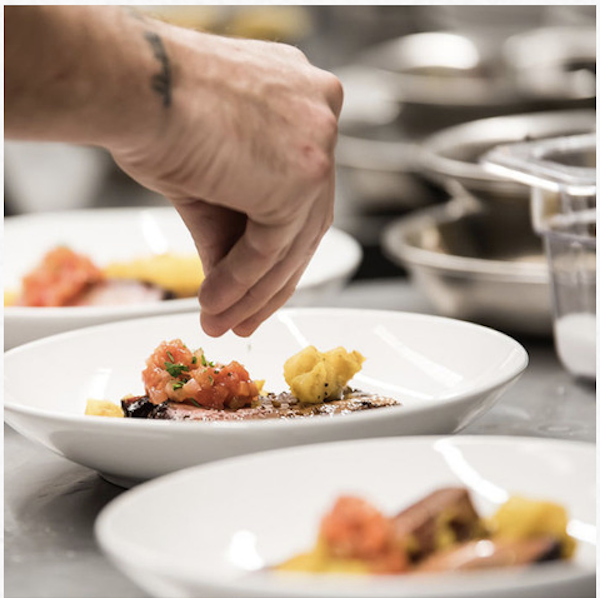 A chef's hand seasoning 3 bowls of food from Fall Adventures In Asheville NC