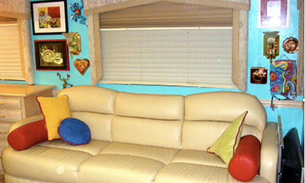 A cream colored sofa with throw pillows and a turquoise wall from Simple Ideas For Renovating Your RV