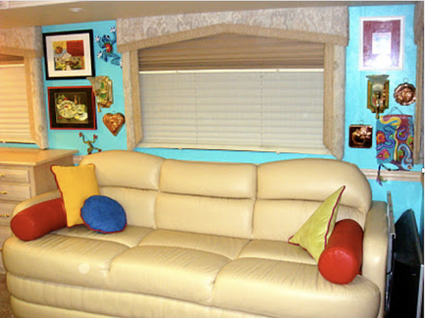 A cream colored sofa with throw pillows and a turquoise wall from Simple Ideas For Renovating Your RV