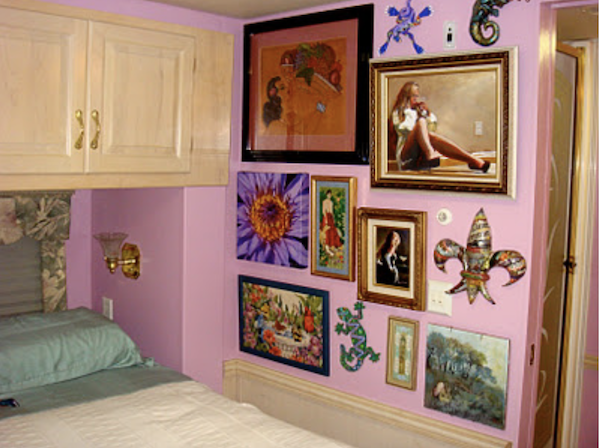 An RV bedroom with mauve walls and artwork from Simple Ideas For Renovating Your RV