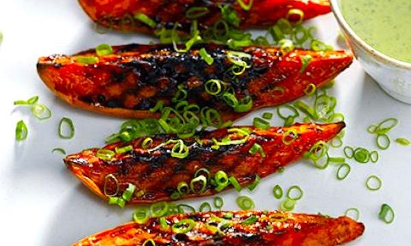 A white platter topped with grilled sweet potato wedges and parsley from Squeezable Mighty Sesame Tahini