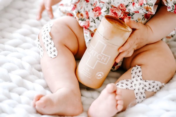A baby with fun print bandages on her legs from Fun Camping Essentials