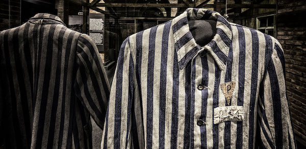 A black and white prison uniform from Uniform worn by Marian Kostuch, held as a Polish political prisoner. Kostuch was born on June 8, 1922, in Bieżanów. His occupation was listed in camp records as “tanner.” © Musealia