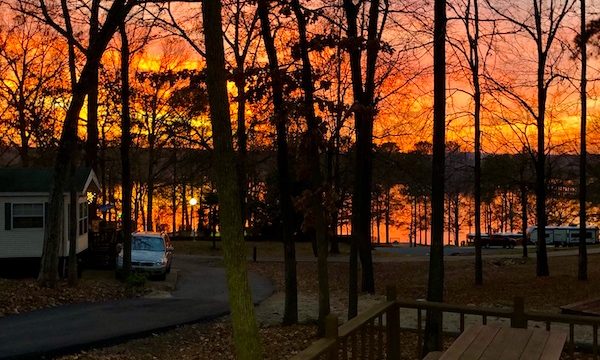 A fiery sunset through trees and over a lake at our 1st Stop - Greensboro, Georgia