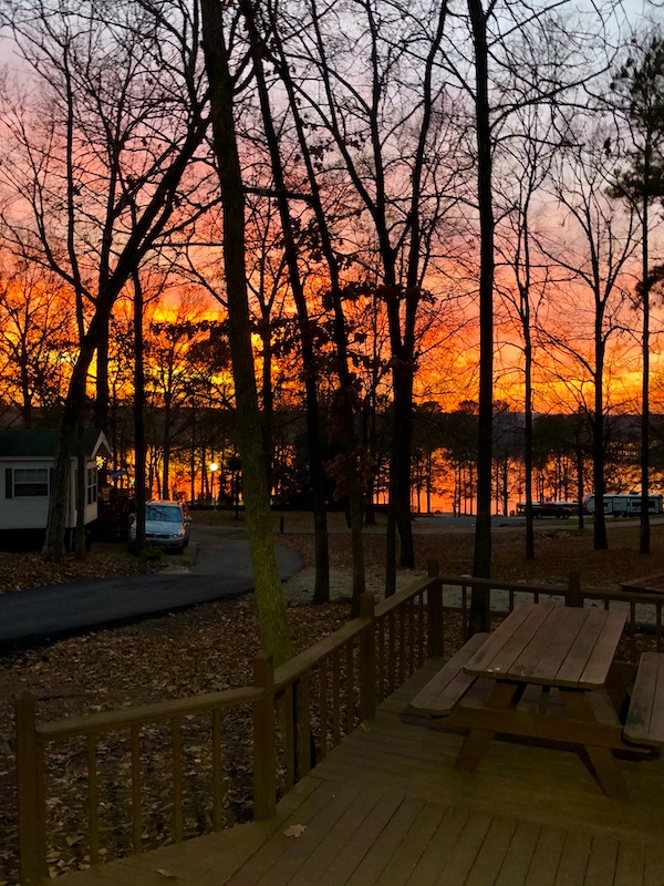 A fiery sunset through trees and over a lake at our 1st Stop - Greensboro, Georgia