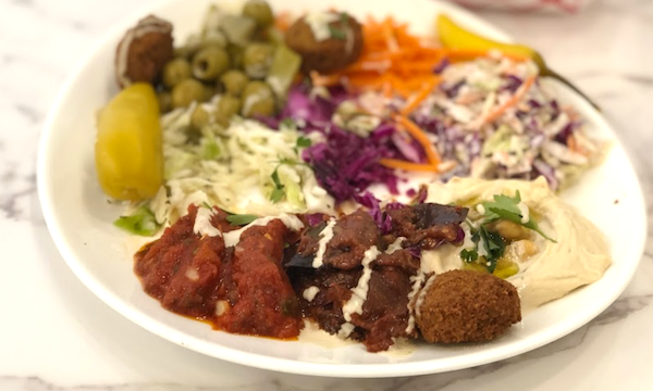 A plate topped with falafel, coleslaw and other items from Friendship Café on Las Olas