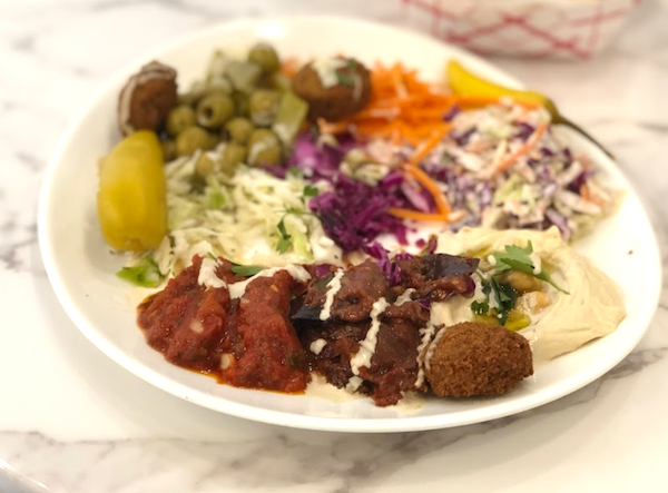 A plate topped with falafel, coleslaw and other items from Friendship Café on Las Olas
