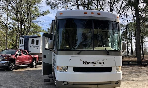 The front of a white and tan RV from Happy Campers