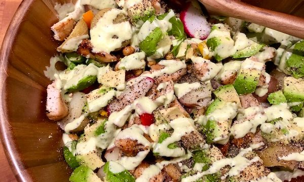 A Healthful Chicken Salad with Creamy Yogurt Dressing in a wood bowl