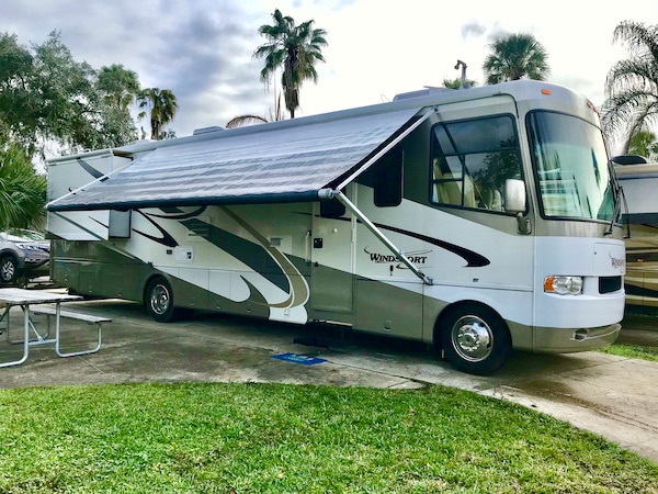 An RV with the awning out at Tropical Palms RV Resort