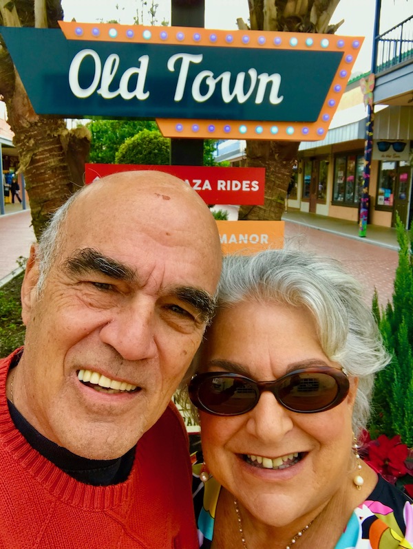 A couple standing under a sign for Old Town.