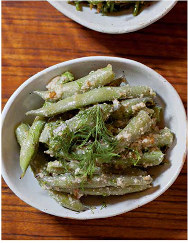 A bowl of wide green beans on a wood table from Istanbul Cult Recipes