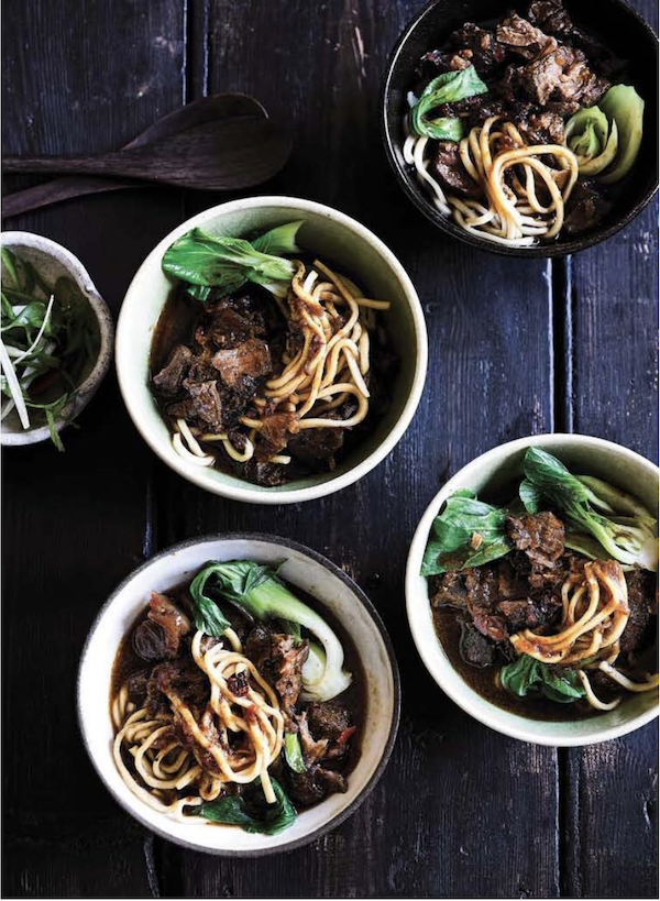 Bowls of beef noodle soup on a wood table from My Asian Kitchen