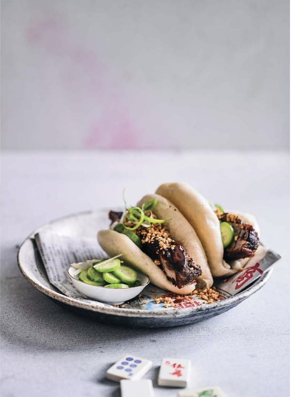 An Asian designed plate topped with steamed buns and cucumber salad from My Asian Kitchen