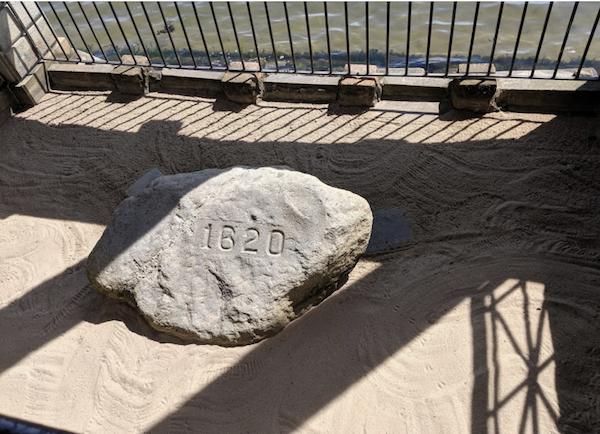 A rock on sand enclosed by a fence at Plymouth Massachusetts