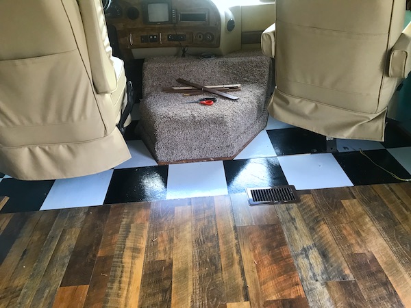 A wood floor transitioning to a black and white checkered floor in an RV from Another RV Renovations Update