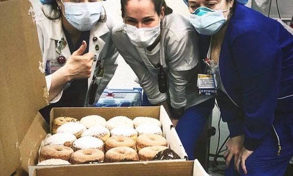 Three healthcare workers in their PPEs ready to enjoy Doughnuts for First Responders