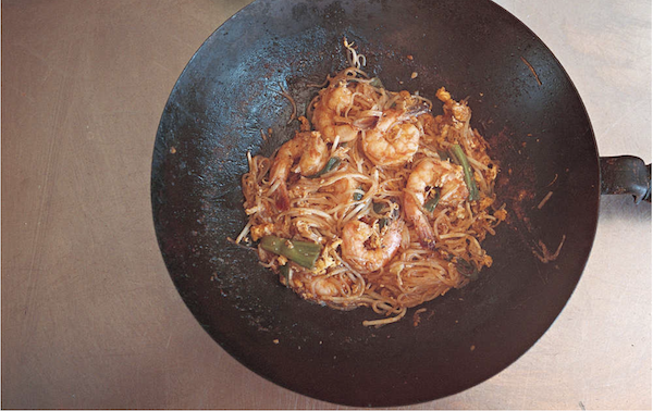 A carbon steel wok filled with prawns, noodles, sauce and scallions from Los Angeles Cult Recipes