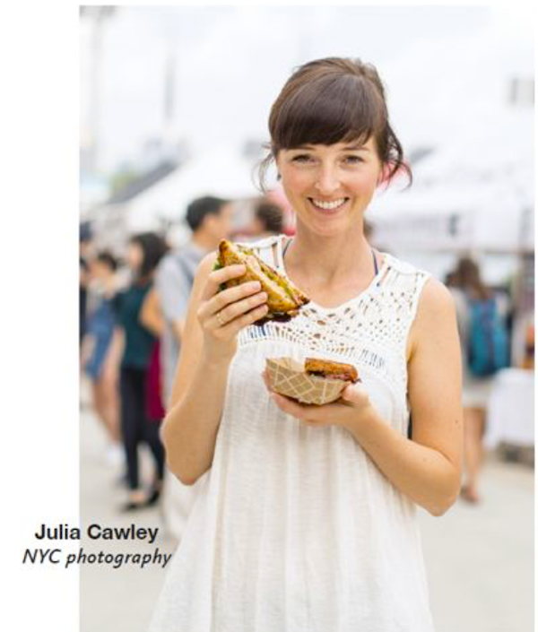 A woman in a white dress holding a sandwich from New York Capital of Food