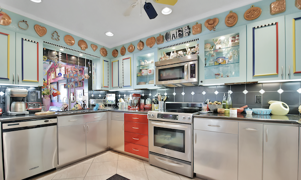 An aqua kitchen with stainless steel base cabinets and red drawers from Ready to Live Our Dream