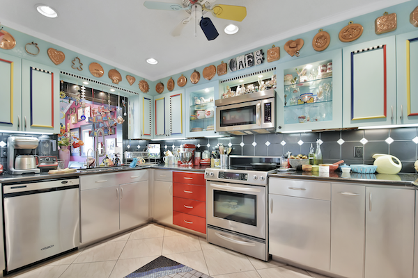 An aqua kitchen with stainless steel base cabinets and red drawers from Ready to Live Our Dream