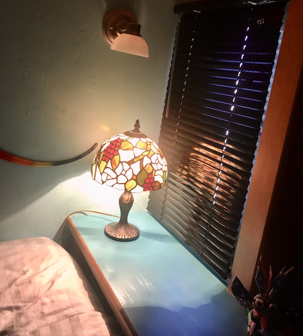 An RV bed and night stand with Tiffany lamp from Ready to Live Our Dream