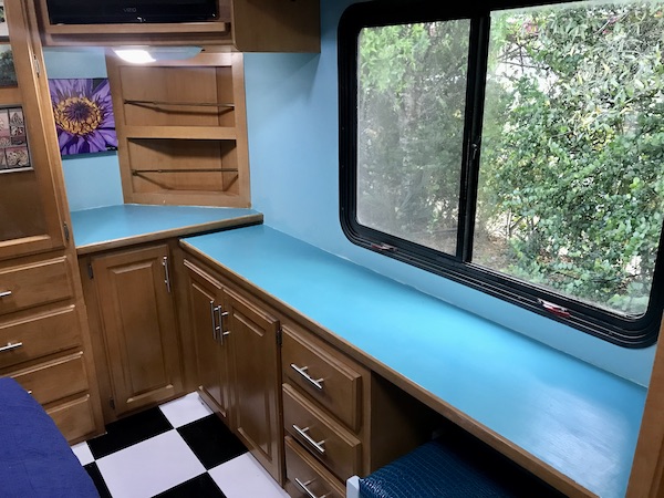 An RV bedroom with turquoise counters and wood drawers from Ready to Live Our Dream