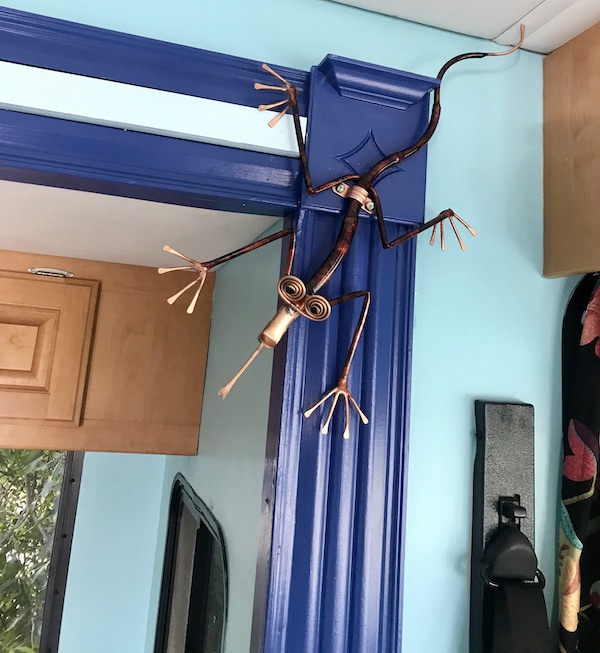 A blue archway with a copper lizard sculpture from Ready to Live Our Dream