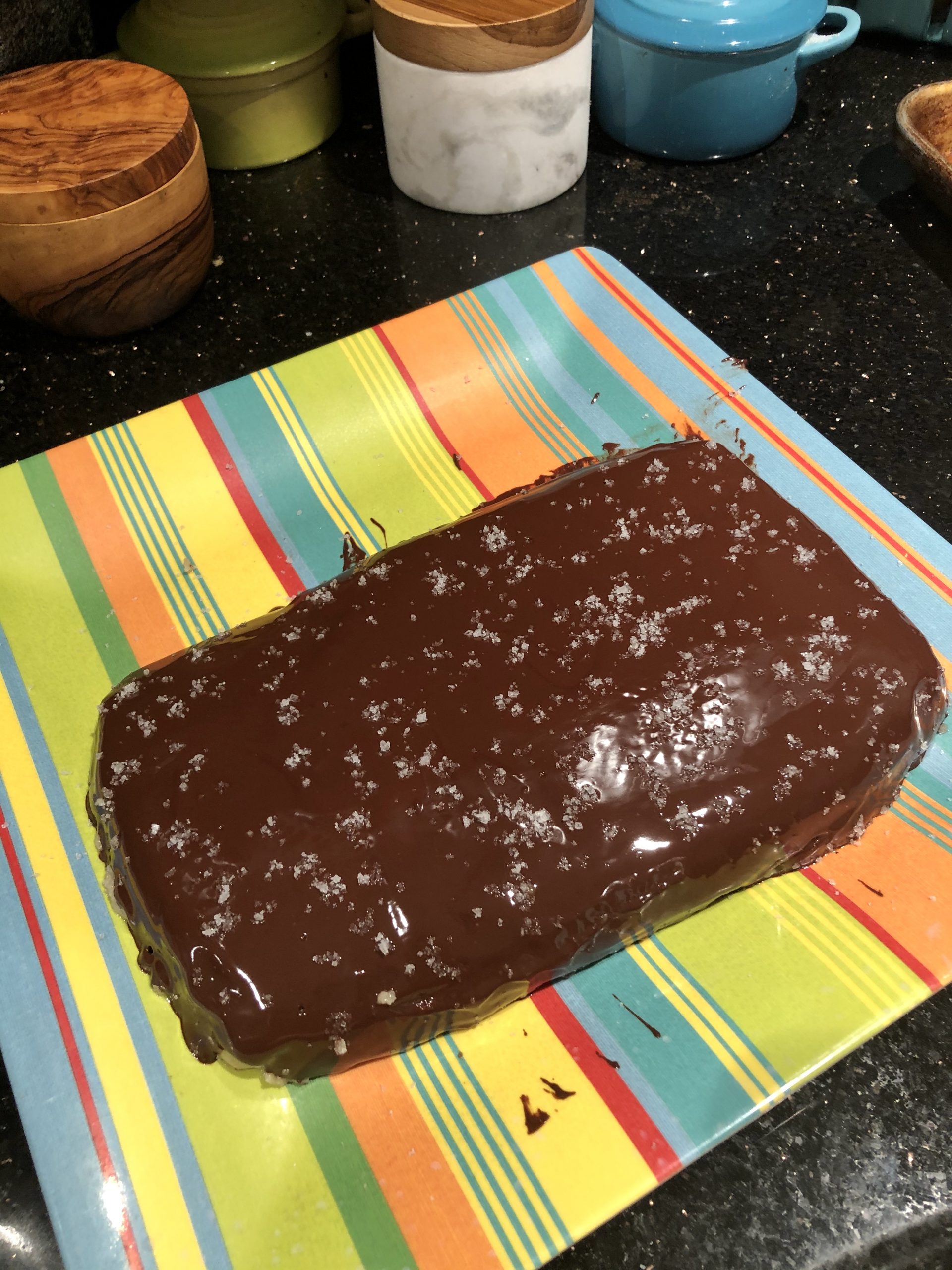 A loaf of Salted Chocolate Covered Halvah on a striped plate