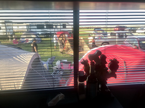 Tents seen through a window with mini blinds at Cedar Island Resort in NC