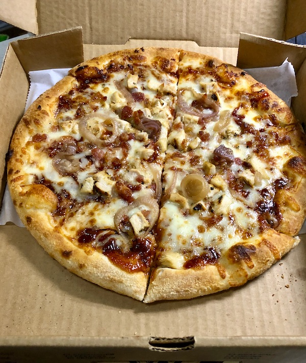 A pizza with toppings in a box from