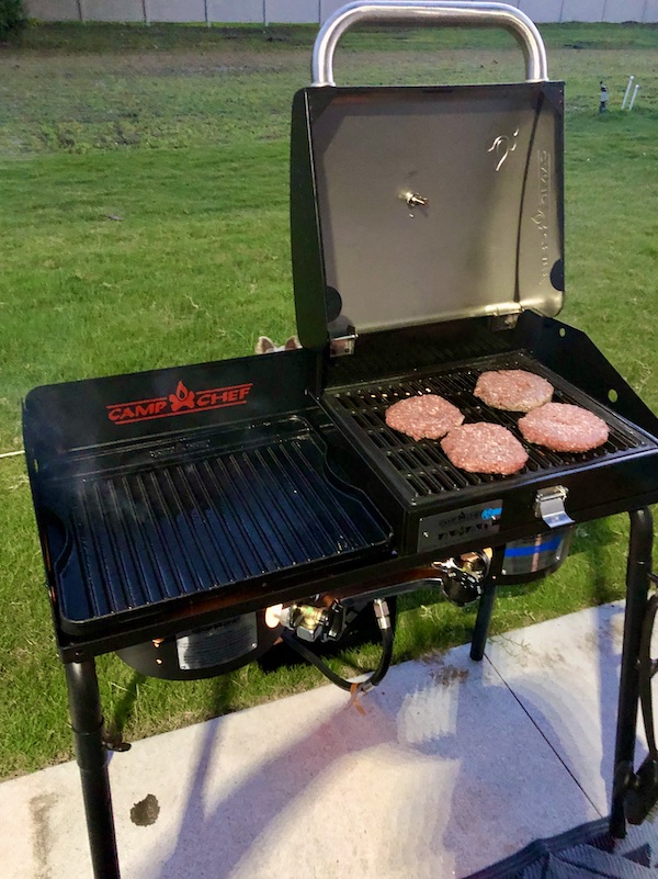 Four burgers being cooked on a grill from Grillin' and Chillin' in North Myrtle Beach