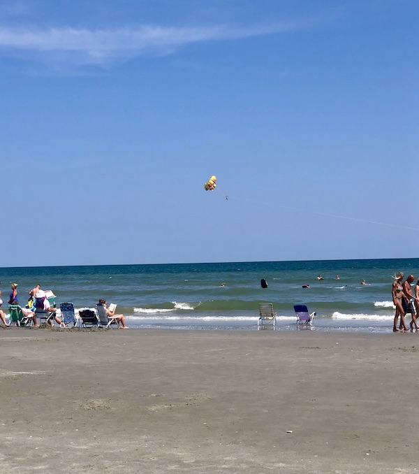 Sand and ocean with people on the beach from Grillin' and Chillin' in North Myrtle Beach