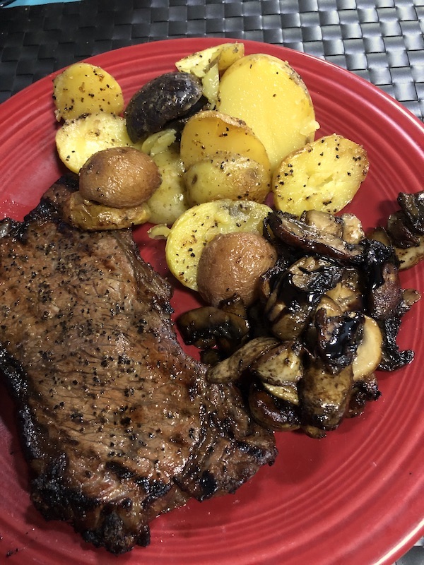 A red plate topped with steak, potatoes and mushrooms from Grillin' and Chillin' in North Myrtle Beach
