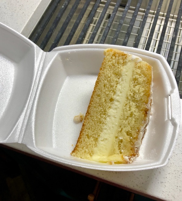 A slice of lemon cake in a styrofoam clamshell from Little Duck Diner, Savannah
